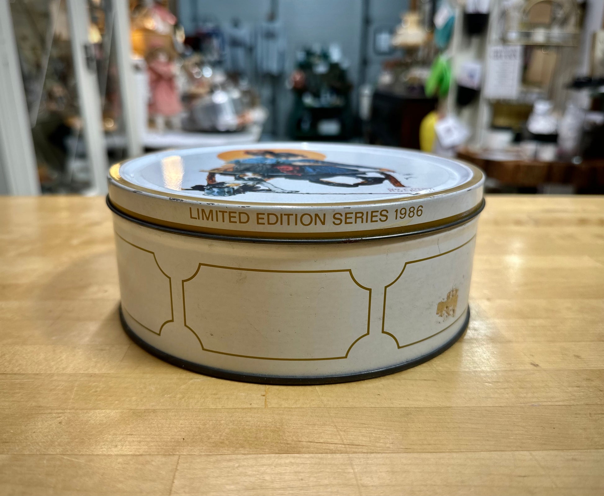 Side view of 1980’s Norman Rockwell illustrated cookie tin