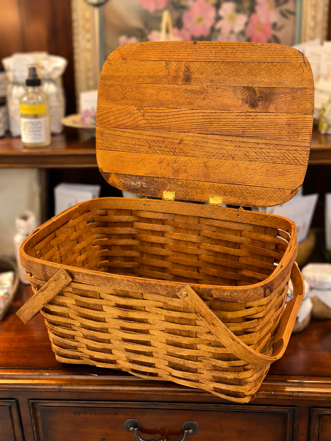 Open vintage woven wood picnic basket showing interior and wooden lid