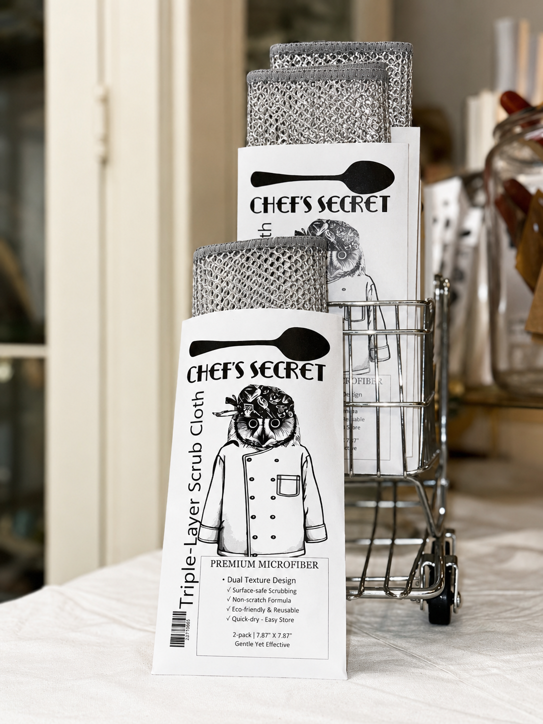 Two packs of 'Chef's Secret' triple-layer scrub cloth on a kitchen counter.