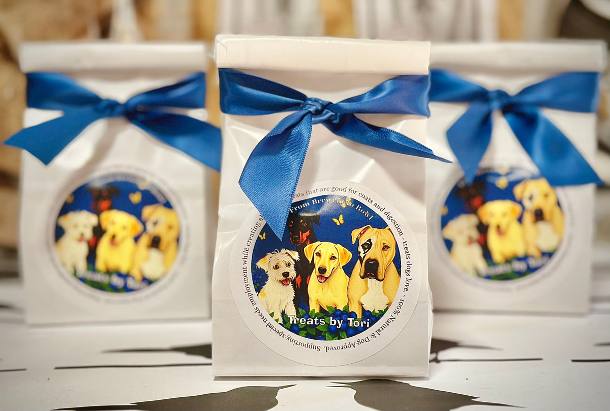 Three gift bags of Treats by Tori blueberry dog treats tied with blue ribbon