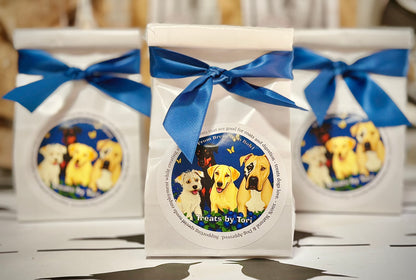 Three gift bags of Treats by Tori blueberry dog treats tied with blue ribbon