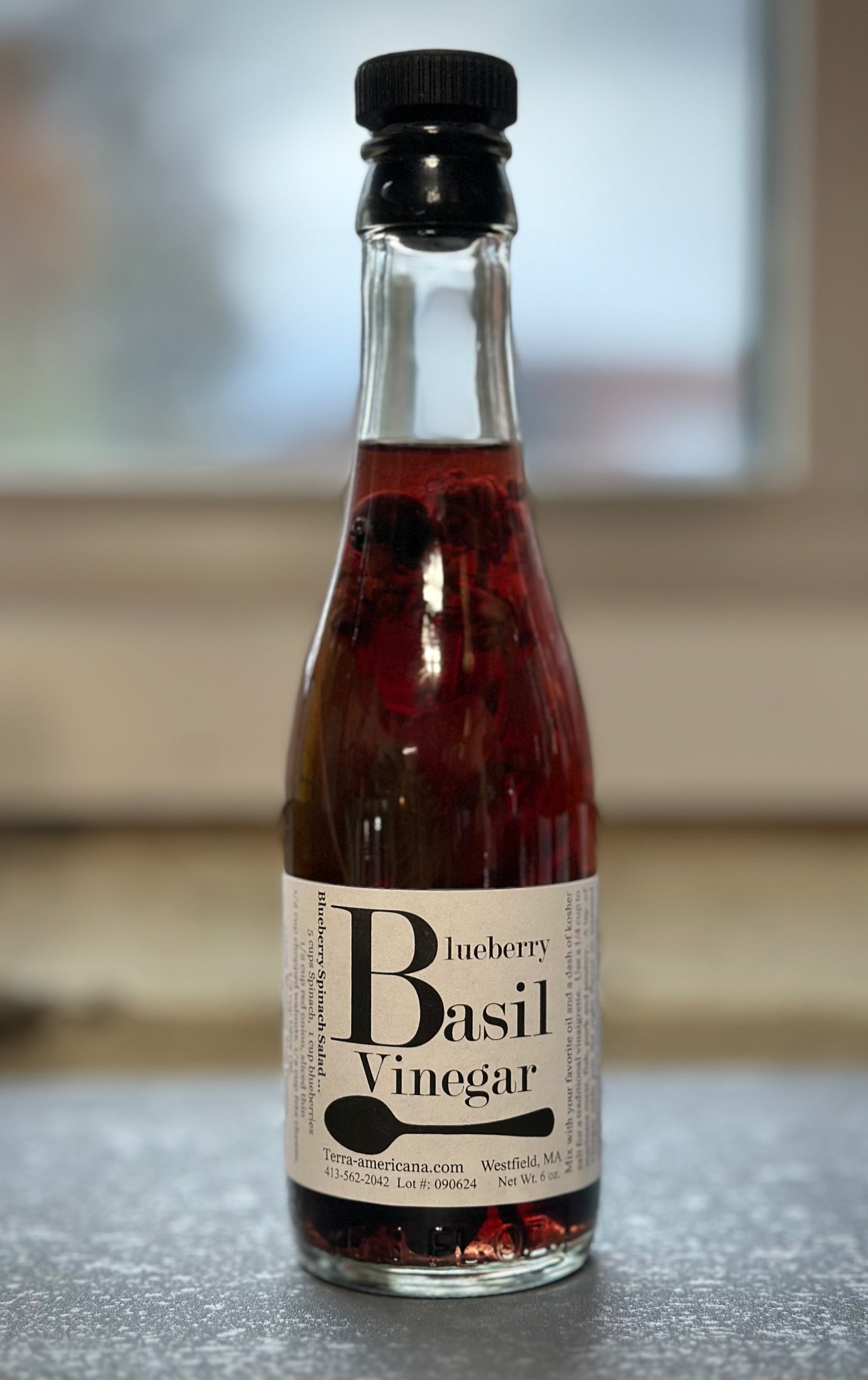 Blueberry basil vinegar bottle with farm-grown purple basil leaves