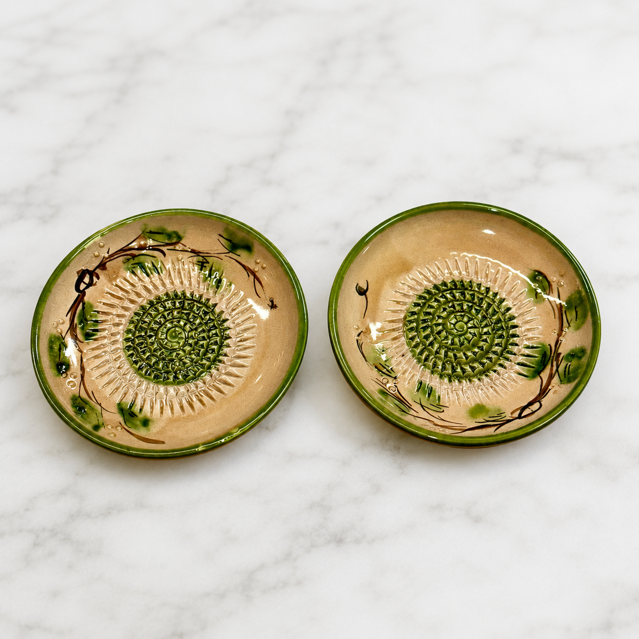 Handmade ceramic garlic grater dish made in Spain showing raised grating center and green olive branch pattern