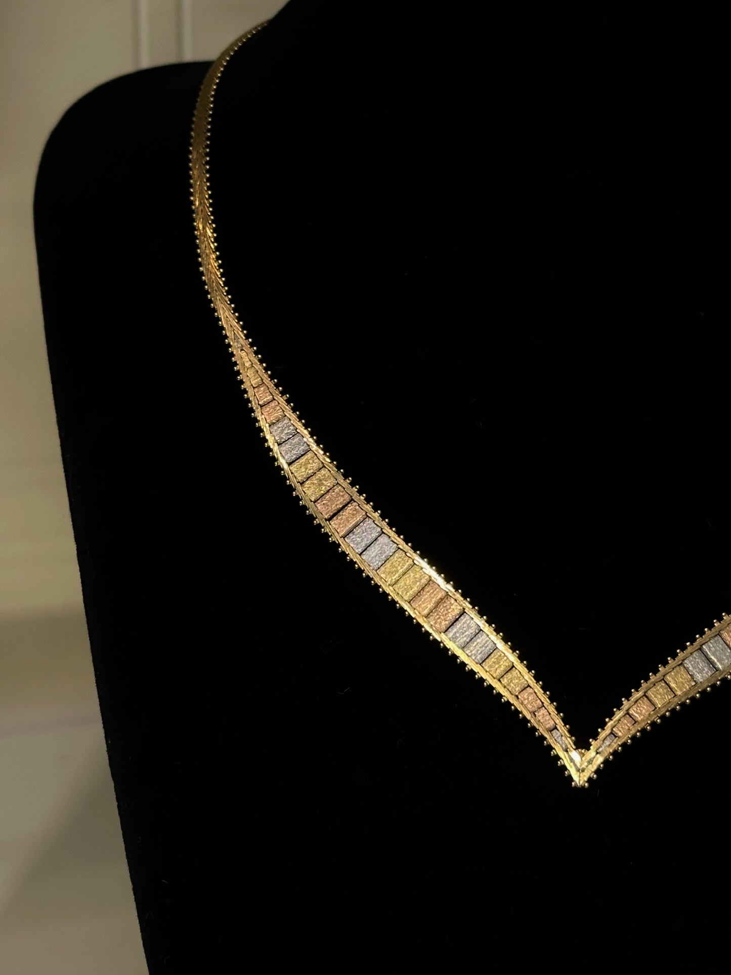 Necklace with multicolored stones on a black stand