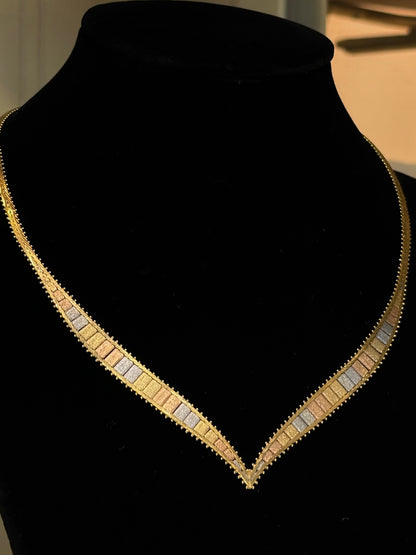 Gold necklace on a black mannequin