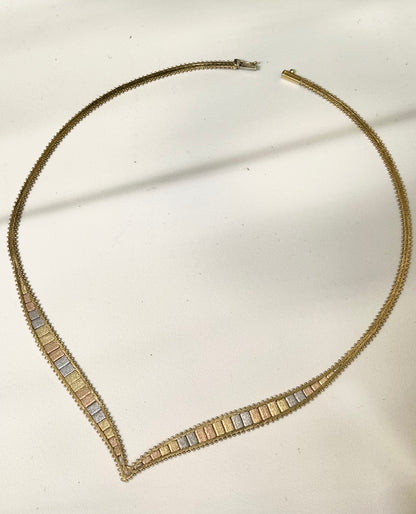 Necklace with gold and silver beads on a light background