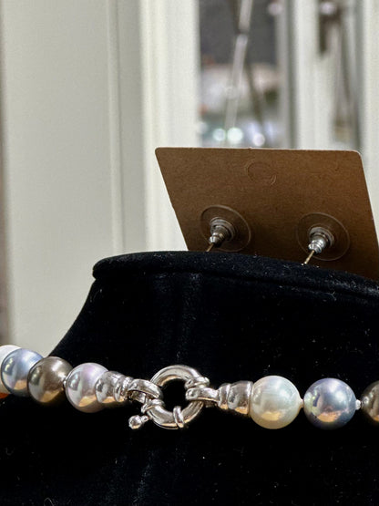 Pearl necklace and earrings on a black stand 