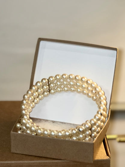 Pearl necklace in a jewelry box on a neutral background
