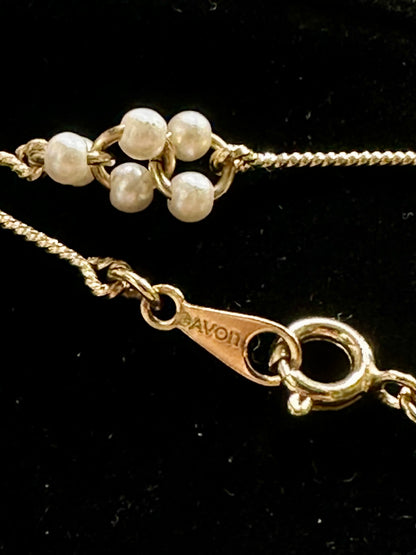 Close-up of a gold filled chain with pearl-like beads and a clasp 