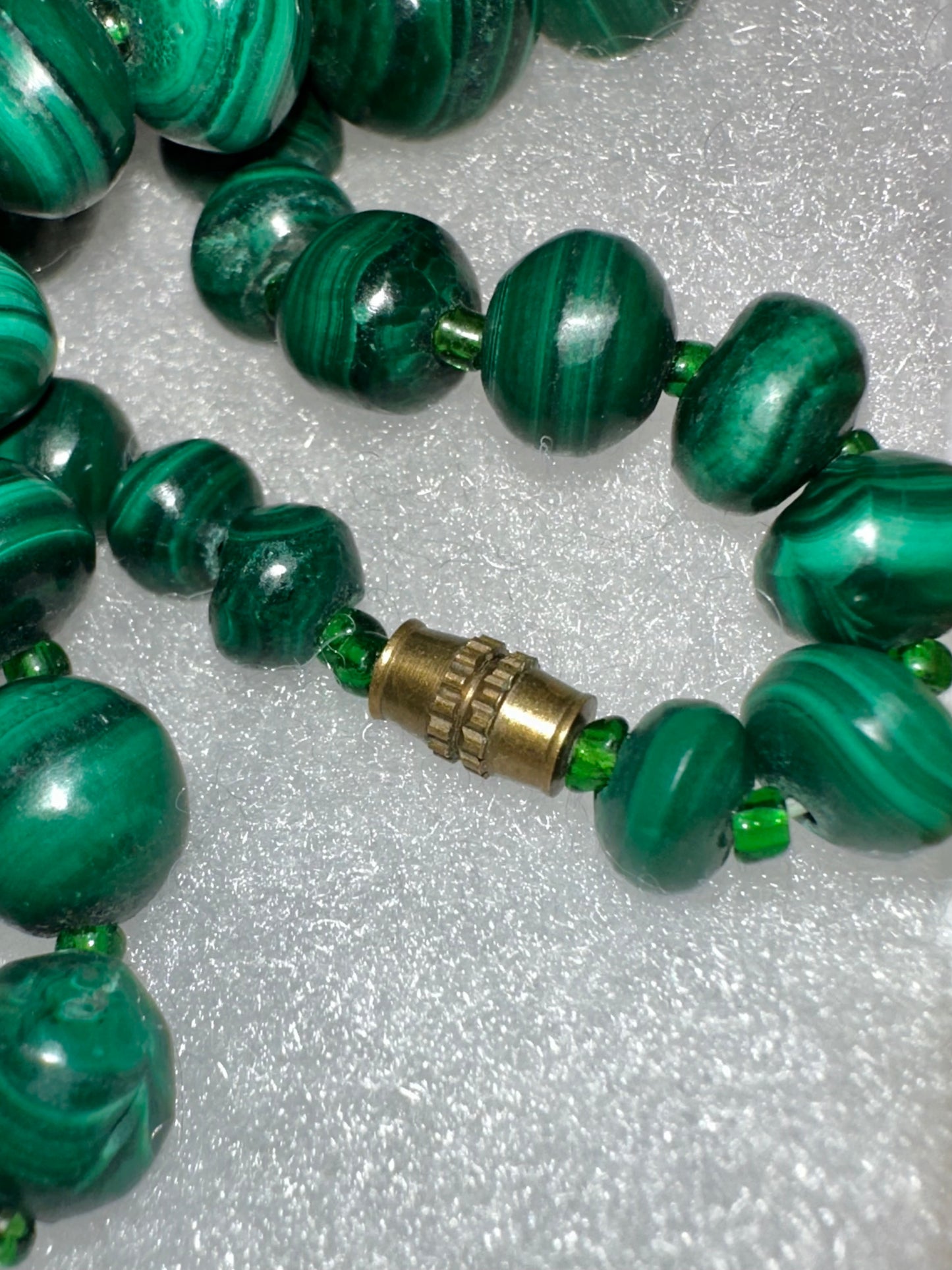 Polished malachite gemstone necklace display