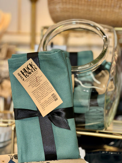 Green Huck towels with a black ribbon displayed 