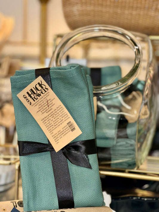 Green Huck towels with a black ribbon displayed 