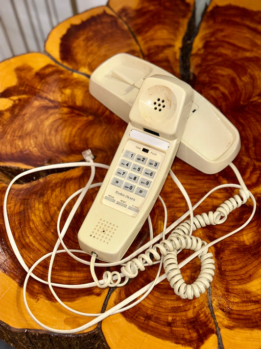 Retro beige corded telephone with coiled handset cord