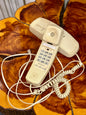 Retro beige corded telephone with coiled handset cord