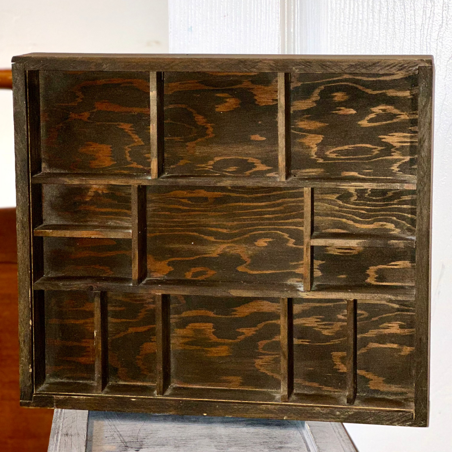 Geometric wooden curio shelf with decorative compartments for displaying collectibles, crystals, and figurines
