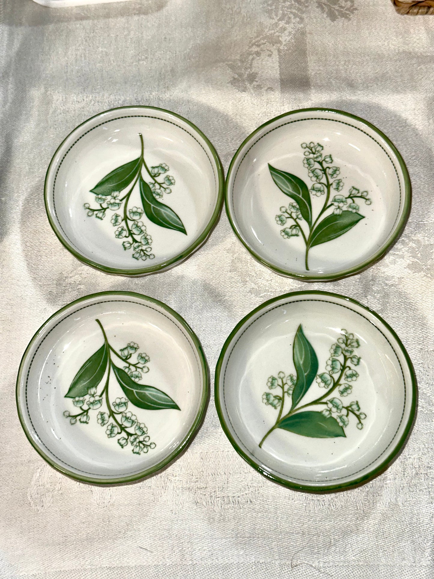 Ceramic cereal bowls featuring Lily of the Valley flowers.