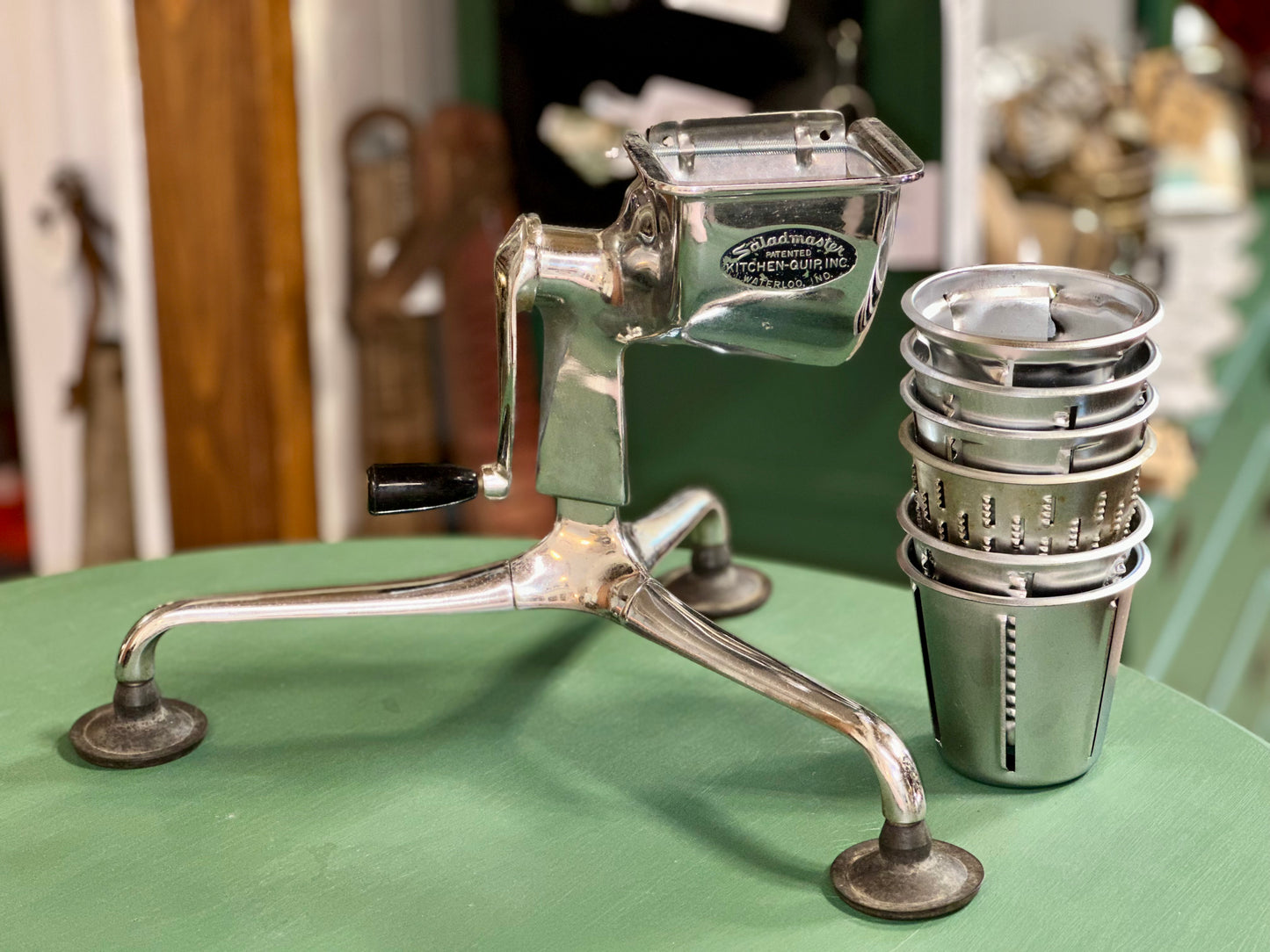 Vintage Saladmaster hand crank food processor with six interchangeable drums.