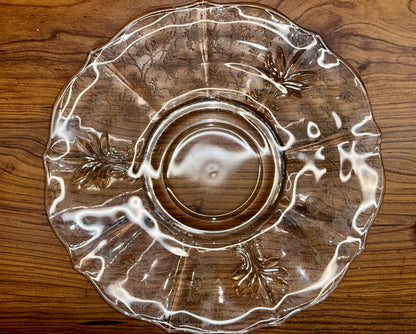 Vintage clear glass serving plate with scalloped edge and decorative scroll design
