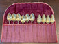 Vintage silverplate serving spoon set in purple fabric storage roll