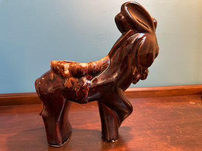 Side profile of large vintage donkey planter featuring raised saddle and floral details