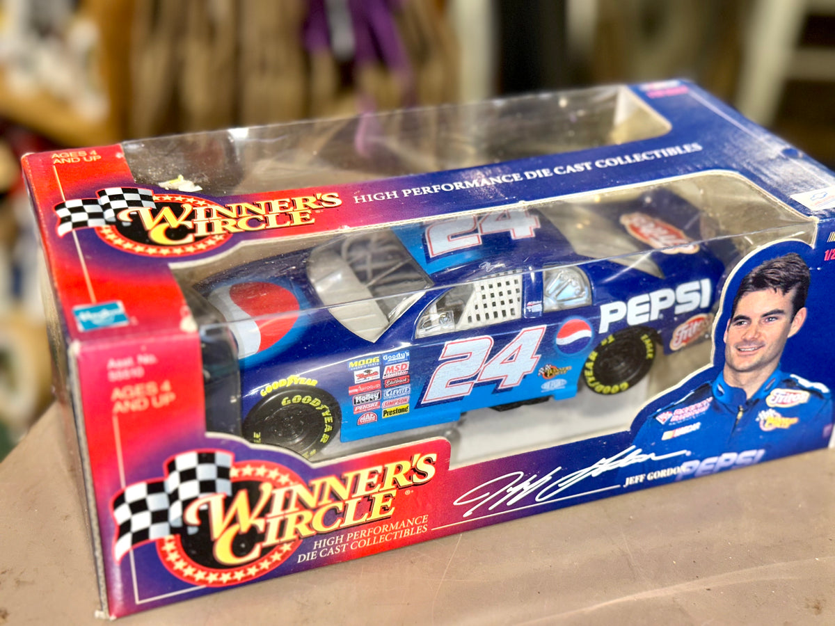 Die-cast collectible race car in a clear plastic window box. 