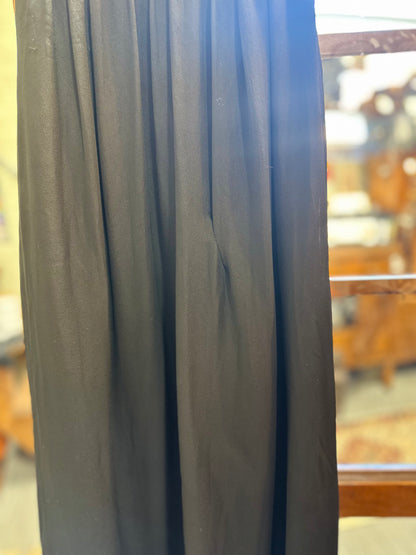 Close-up of the flowing black chiffon fabric showing the gown's soft gathered construction, draped texture and a small repair.