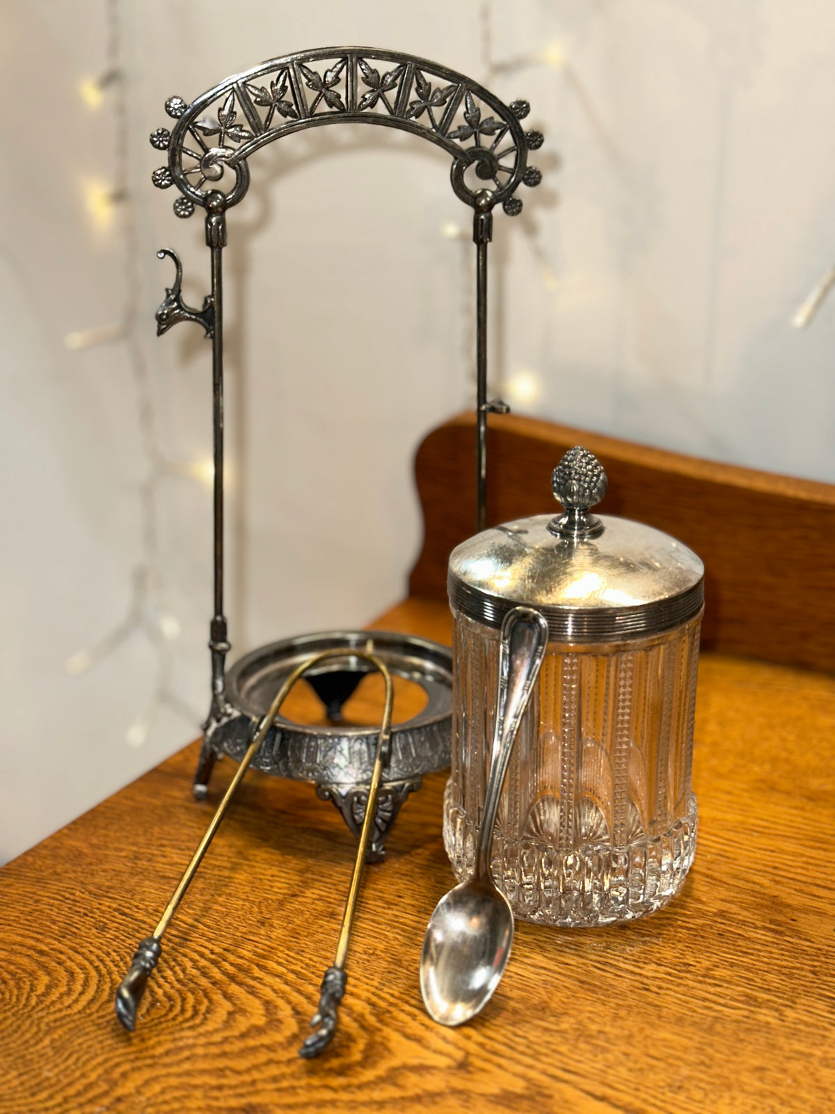 Vintage glass biscuit jar with the lid removed, revealing the spoon and tongs.