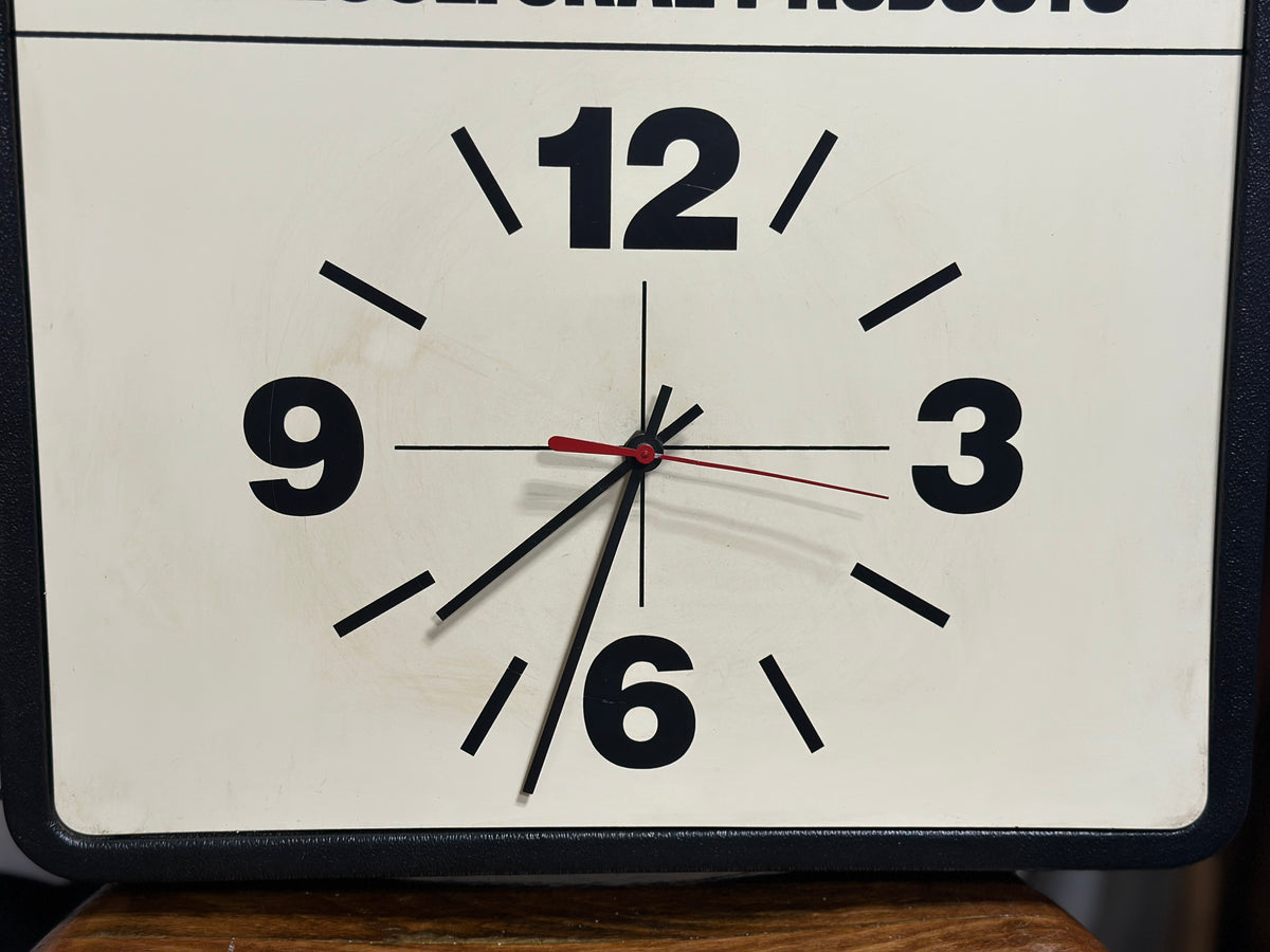 Close-up of the clock face showing the large black 12, 3, 6, and 9 numerals and the vintage hands in their present as-is condition.