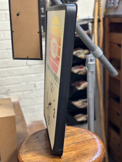 Side view of the vintage DuPont Agricultural Products clock showing the depth of the black molded case and a small crack close to the bottom of the case.