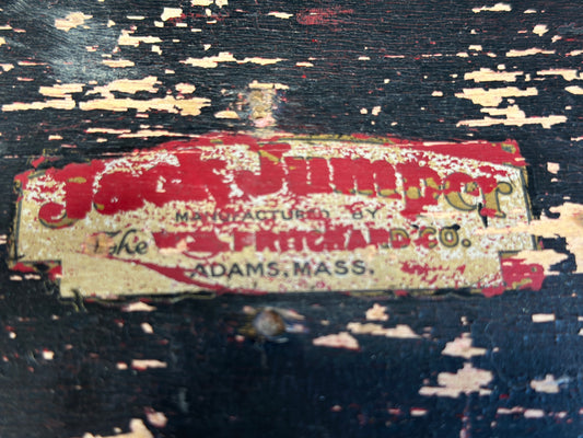 Close-up of worn original manufacturer's label on antique jack jumper sled, showing Adams, Massachusetts.