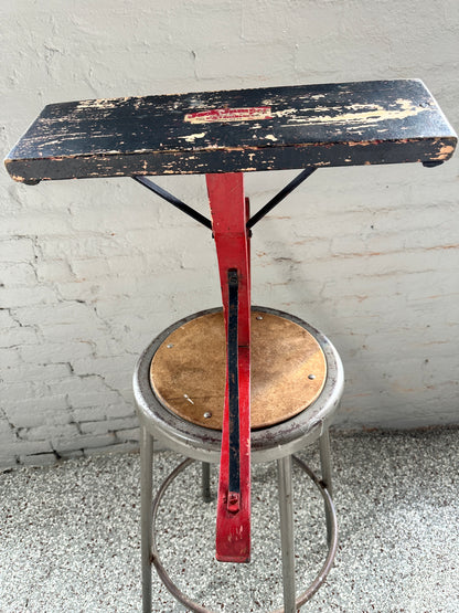 Antique New England jack jumper sled showing the black-painted wooden seat, red upright and metal support rods.