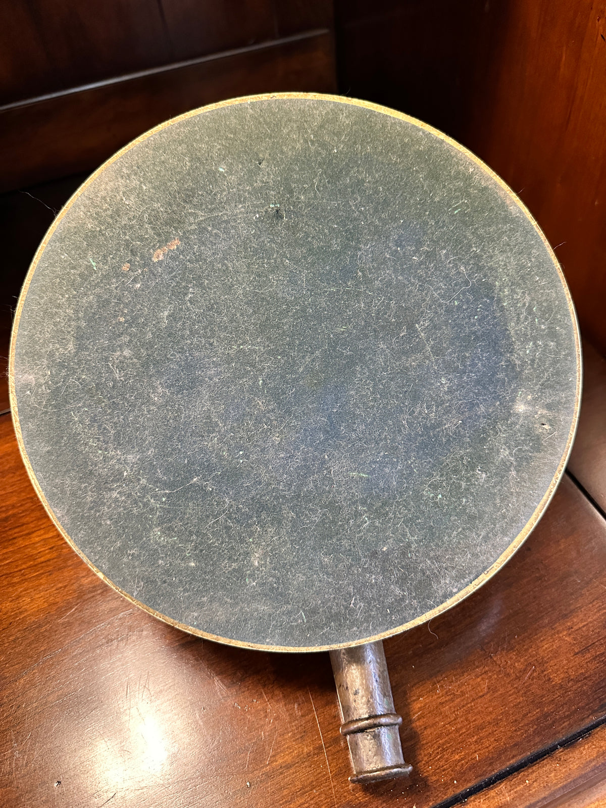 Underside of vintage noon cannon sundial showing black felt-covered backing on the 9.5-inch circular base.