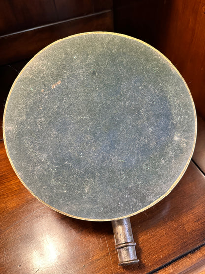 Underside of vintage noon cannon sundial showing black felt-covered backing on the 9.5-inch circular base.