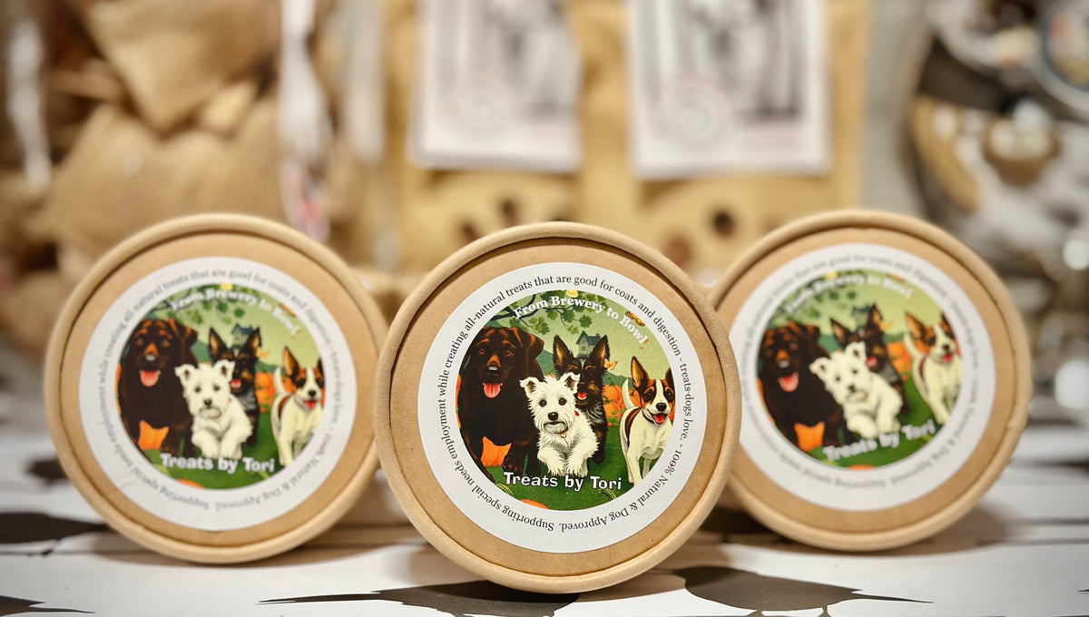 Three kraft tubs of Treats by Tori all-natural dog treats on display